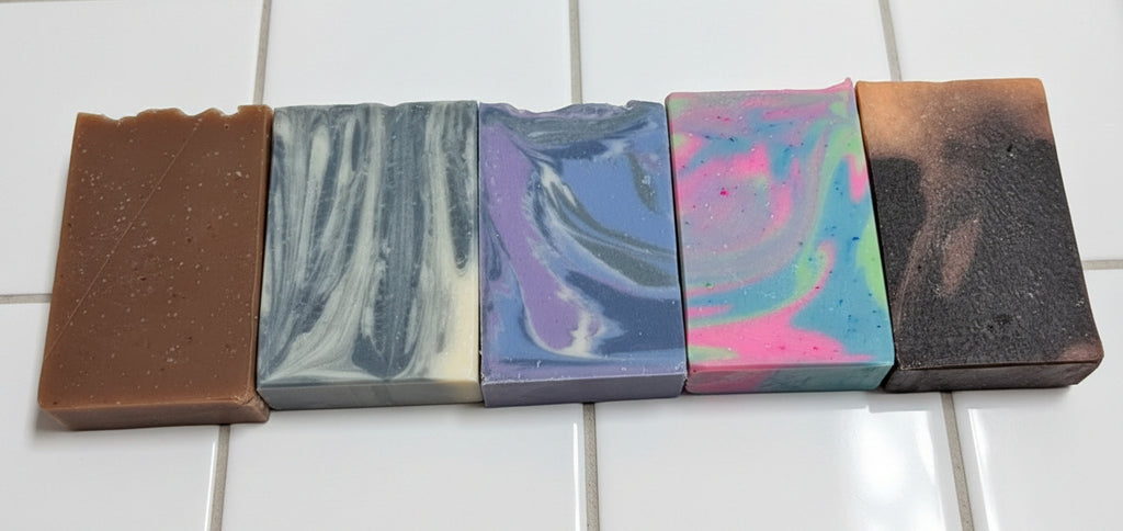 5 soap bars with colorful patterns on a white tile background